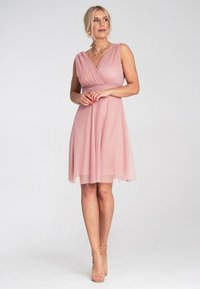 Helles pinkes knielanges Kleid mit V-Ausschnitt, plissiertem Oberteil und fließendem Chiffonrock. Mit Spaghetti-Trägern und tailliertem Bund.