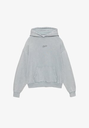 Džemper u svijetlo plavoj boji, napravljen od mekanog materijala. Ima kapu, prednji džep i izvezenu oznaku. Opustenog je kroja s rebrastim manžetama.