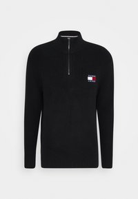 Suéter negro de punto con media cremallera y textura acanalada, que presenta un pequeño parche de logo en azul, rojo y blanco en el pecho izquierdo.