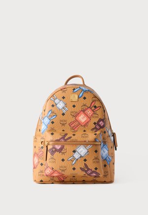 Tan leather backpack with playful bunny graphic patterns in red, blue, and white. Features a front zip pocket and a top handle.