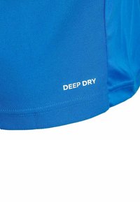 T-shirt de sport bleu avec une surface texturée. "DEEP DRY" imprimé en blanc près de l'ourlet. Manches courtes et bord inférieur arrondi.