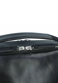 Borsa a tracolla in pelle nera con una texture liscia, dotata di una cerniera in metallo argentato e di un manico arrotondato. Etichetta del logo visibile sul lato.