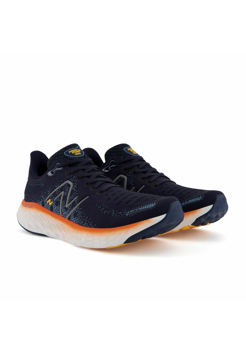 Zapatillas de running azul marino con una parte superior de punto texturizado, entresuela naranja y blanca, y detalles reflectantes. Cuenta con una suela acolchada para mayor comodidad.