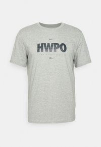 Camiseta de algodón gris con mangas cortas, que presenta el texto "HWPO" en azul marino oscuro, con letras adicionales abajo. Textura suave, diseño casual.