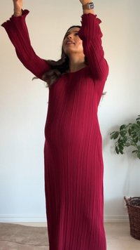 Sarkana ribota kleita ar garām piedurknēm un volāniem manžetēs, veidota brīvam siluetam. Audumam ir fakturēta virsma un tas skaisti krīt.