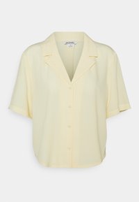 Chemise jaune à manches courtes boutonnée, en tissu léger avec col à revers et coupe carrée. Caractéristiques : éclat subtil et design minimaliste.