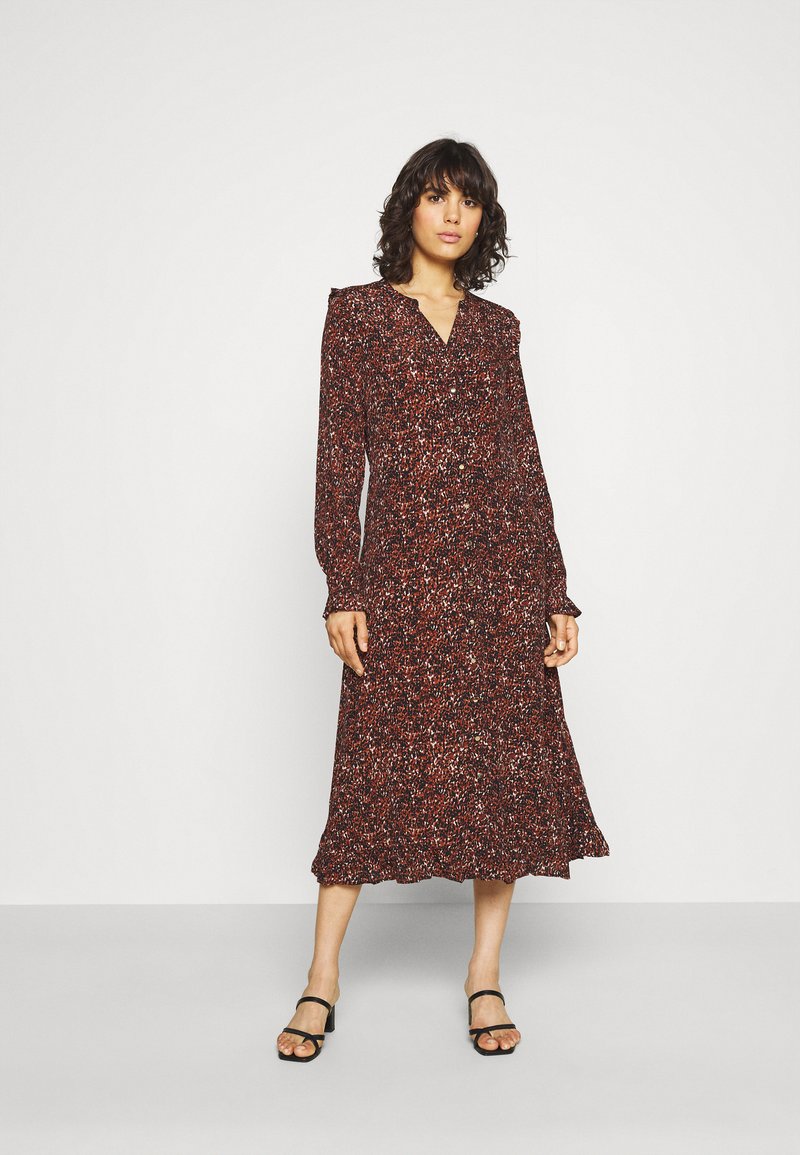 Robe à manches longues, longue jusqu'aux chevilles, dans un motif floral rouge avec des accents volantés aux épaules et à l'ourlet ; tissu léger avec une texture lisse.