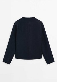 Veste bleu marine à manches longues avec un ourlet droit et une couture visible courant au centre du dos sur fond blanc.