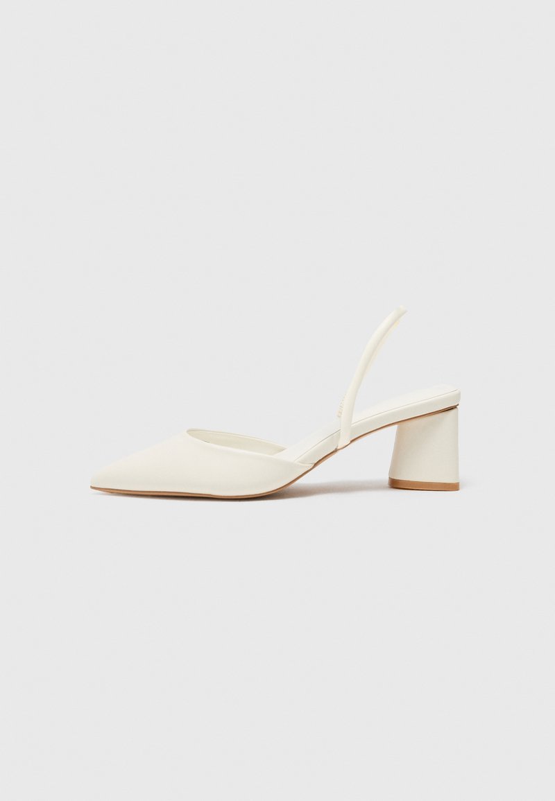 White slingback heeled shoe with a pointed toe, smooth texture, and a block heel. Features a thin strap at the back for secure fit.