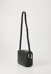 Black leather crossbody bag with a rectangular shape, gold-tone hardware, adjustable strap, and zip closure on the top.