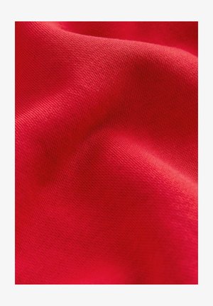 Red fabric with a smooth texture and subtle stretch, featuring a fine-knit pattern that highlights its vibrant color and softness.