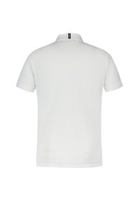 Polo shirt blanc à manches courtes fait d'un tissu lisse avec un col côtelé, comportant une étiquette logo au dos et sans motifs visibles.