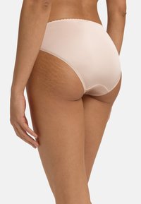 Mutande alte di colore rosa chiaro, realizzate in un materiale liscio, con cuciture decorative lungo la vita e uno stile a copertura minima.