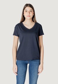 Maglietta a V in navy scuro realizzata in cotone morbido, con maniche corte, design aderente e una piccola etichetta con logo sul petto.
