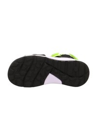 Semelle extérieure en caoutchouc noir avec des crampons profonds, intercalaire blanche à la texture lisse, et sangles Velcro vert fluo pour un ajustement sûr.