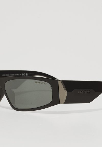Mustad prillid geomeetrilise disainiga, tumedad läätsed ja metallist aksessuaarid raamile. Templi peal on "JIMMY CHOO" bränding.