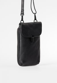 Borsa a tracolla in pelle nera con chiusura a patta, zip lungo il bordo e tracolla regolabile. Texture liscia con dettagli di cucitura discreti.