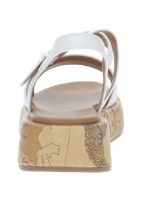 Sandali bianchi con cinturini presentano una suola a piattaforma con una stampa della mappa del mondo, forma arrotondata e texture liscia su una base marrone.