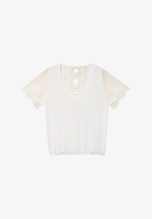 Blouse blanche à manches courtes avec col en V et détails en dentelle sur les manches et le haut de la poitrine avec des découpes en forme de losange.