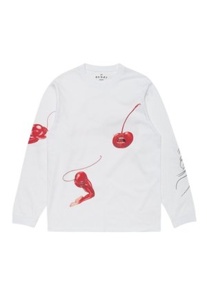 Camicia bianca a maniche lunghe con ciliegie rosse che presentano arti e volti simili a quelli umani stampati sulla parte anteriore e sulle maniche.