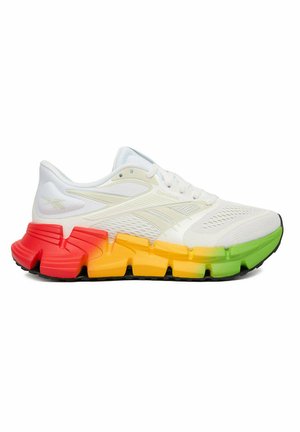Zapatilla blanca de Reebok con parte superior de malla transpirable y suela segmentada en colores degradados rojo, naranja, amarillo y verde.