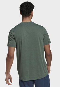 Kortärmad t-shirt i olivgrön tyg, med rund halsringning, mjuk textur och rak fåll med en subtil logotagg i botten.