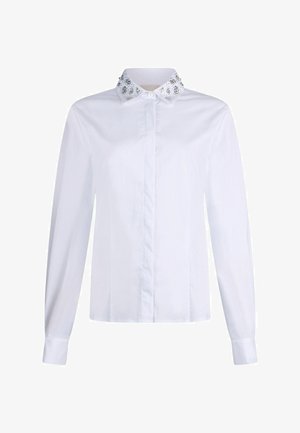 Chemise blanche à manches longues avec devant boutonné et col décoratif orné de perles délicates et de motifs floraux. Matière en coton, texture lisse.