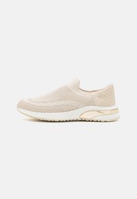 Sneaker beige à enfiler avec texture tricotée, design élancé, talon rehaussé d'or et semelle blanche arborant un motif subtil à l'arrière.