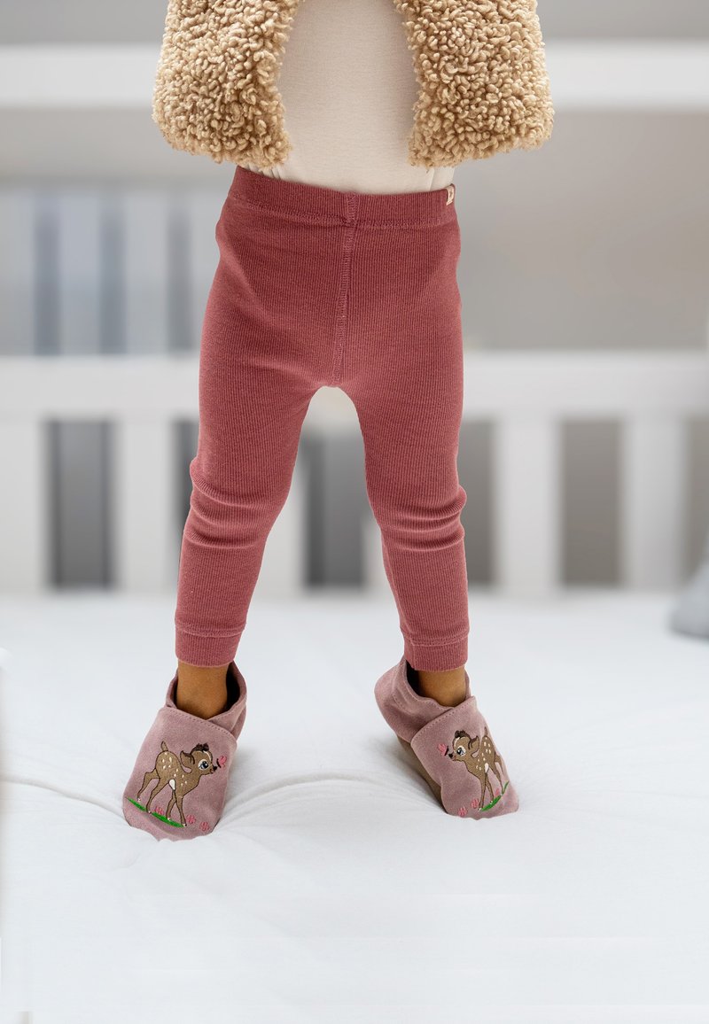 Roze geribbelde legging in combinatie met roze slippers met een ontwerp van een bruine bok. Zachte textuur en een snug fit, geplaatst tegen een lichte achtergrond.