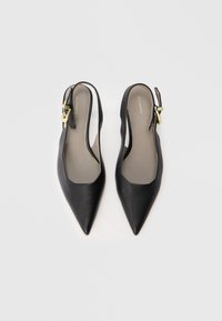 Mustat nahkaiset slingback-korkokengät, joissa on terävät varpaat, avoimet sivut ja kultaisilla yksityiskohdilla varustettu solki. Sileä pinta minimalistisella suunnittelulla.