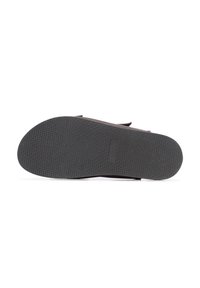 Suola di scarpa in gomma nera con superficie texturizzata per una migliore aderenza, caratterizzata da un leggero arco e un design piatto senza marchi o decorazioni visibili.