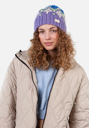 Bonnet en tricot violet avec des accents bleus et verts, présentant un design texturé. Porté avec une veste matelassée beige clair.