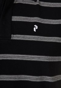 Polo noir avec des rayures horizontales grises, arborant un petit logo blanc brodé sur la poitrine. Texture en tissu de coton doux.