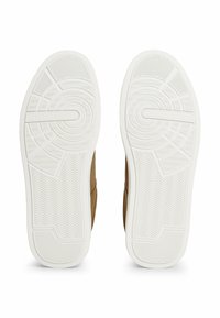 Scarpe in faux suede marrone con suole esterne in gomma bianca, caratterizzate da modelli testurizzati e branding. Il battistrada testurizzato offre aderenza e trazione.