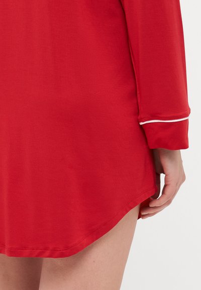 Vestido longo vermelho de mangas compridas, com a barra arredondada, apresentando detalhes em branco nas mangas e uma textura suave e macia.