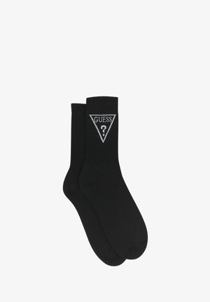 Calzini neri in cotone con una trama a coste e un logo triangolare bianco con la scritta "GUESS" e un punto interrogativo.