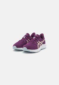 Baskets de sport violettes avec une tige en mesh, des accents dorés et une semelle blanche. Elles présentent une pointe arrondie et un design à lacets pour un maintien sécurisé.