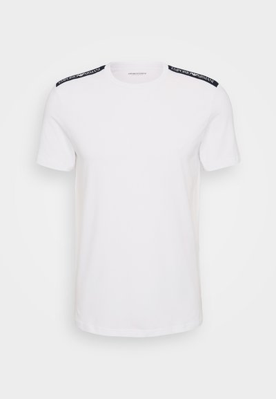 T-shirt bianca in cotone con maniche corte, caratterizzata da dettagli blu navy sulle spalle e un logo discreto sul davanti. Design classico con scollatura a girocollo.