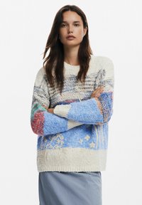Puhább kötött pulóver, több színű mintákkal, lágy kék és krémszín árnyalatokban, virágos hímzéssel az alján és texturált ujjak. 
