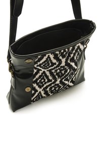 Borsa a tracolla in pelle nera con un pannello in tessuto intrecciato con un motivo geometrico in bianco e nero; include dettagli metallici e un interno con zip.