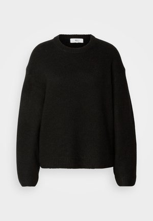 Pull noir en maille avec un col rond, des épaules tombantes, et des poignets et un ourlet côtelés. Tissu doux et texturé avec une coupe ample.