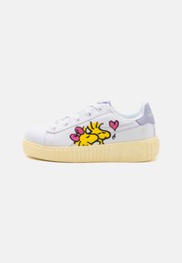 Baskets en toile blanches avec des personnages de dessin animé jaunes imprimés sur le côté, des accents violets et une semelle beige striée. Design à lacets.
