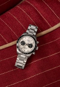 Timex Waterbury kronográf óra rozsdamentes acél szíjjal, fekete lünettával és fehér számlappal, melyen két fekete segédszámlap látható piros texturált anyagon.