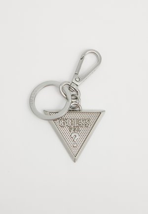 Porte-clés triangulaire en argent avec le mot "GUESS" en relief, surface texturée, attaché à un clip en métal et un anneau pour un attachement facile.