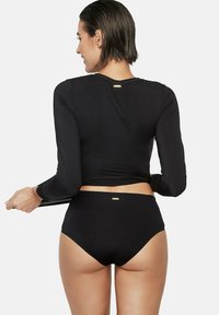 Zwarte zwemtop met lange mouwen en high-waisted onderkant, met een slank ontwerp, een zachte textuur en gouden logo-accenten op de achterkant.