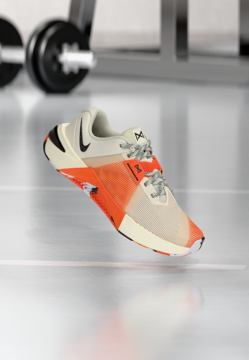 Könnyű sportcipő krém, narancs és fekete színekben. Texturált felsőrésszel, fekete swoosh logóval és mintás talppal a tapadás érdekében.