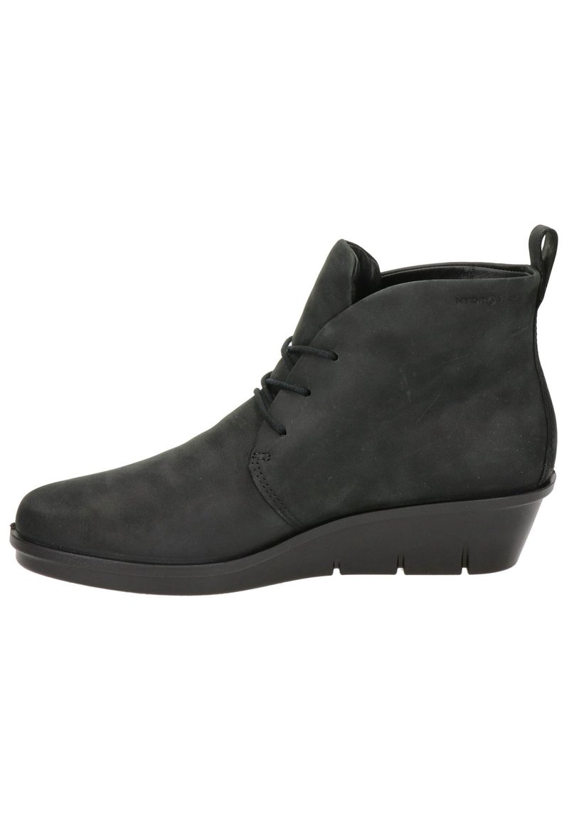 Botines de ante negros con punta redondeada, diseño de cordones y tacón cuña; textura suave con sutilezas en los detalles de costura.