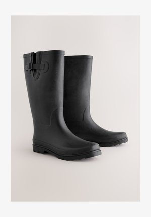 Musta kuminen vedenpitävä saappaat, joissa on sileä pinta, pyöreä kärki ja vahvistettu pohja. Varustettu hihnalla päällä varmistamaan turvallisen istuvuuden.