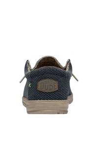 Baskets en toile tissée marine avec des accents beiges, des lacets élastiques et une patch logo à l'arrière. Surface texturée avec une semelle flexible.