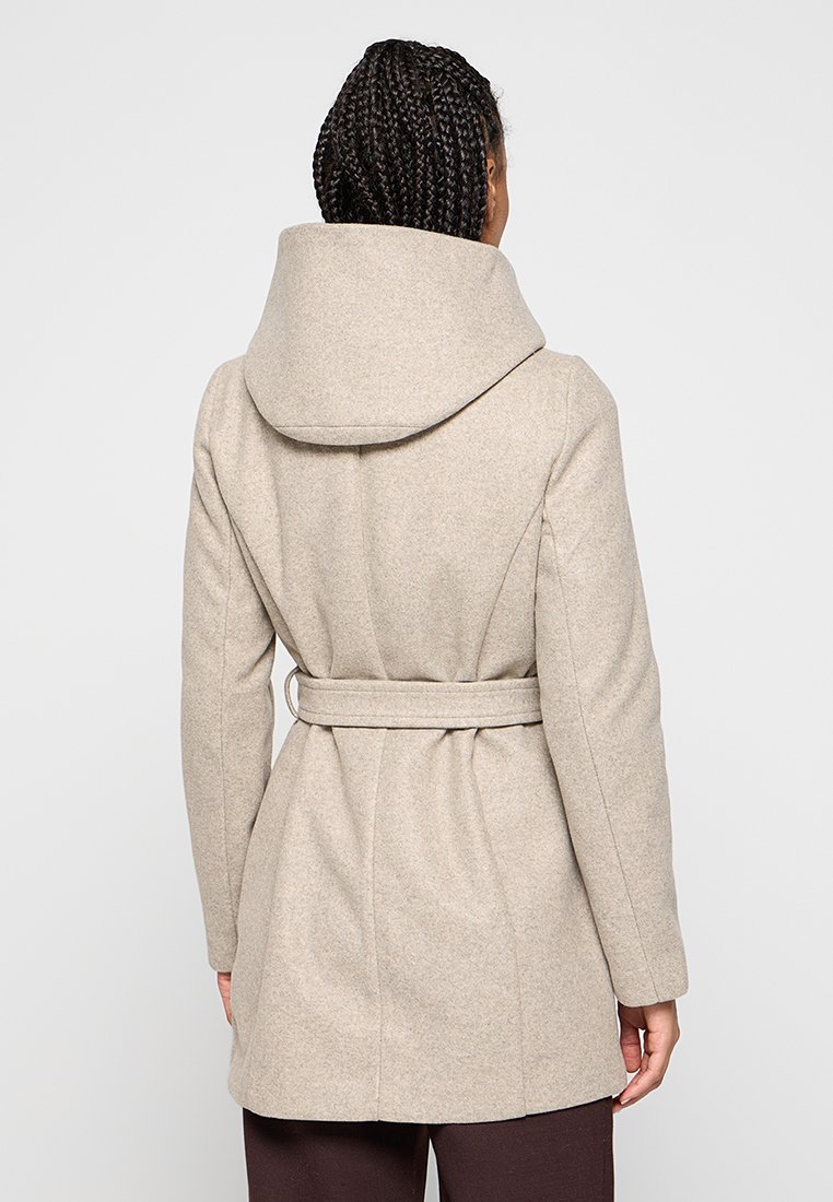 Beige wollen jas met een hoge kraag, een tailleband en een getailleerde pasvorm. Heeft een textuur en een schone, minimalistische uitstraling.